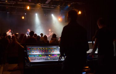 A silhouet image of a person mixing a live band in a gig studio