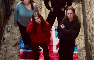 A group of 4 people with the Union Jack flag under them