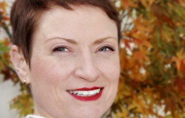 A woman with short hair smiling into the camera