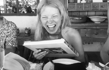 A woman smiling while holding a book 