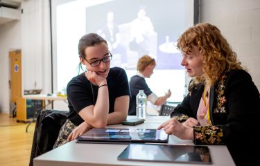 A student and industry person discussing work on a screen