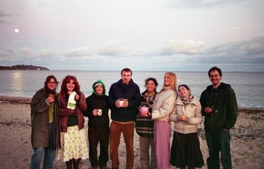 A group of first year Falmouth University student on the beach at dusk