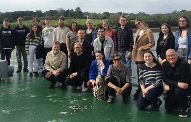 Graphic design staff, students and alumni project team photo on board a boat