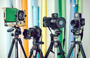 Set of 4 different types of cameras on tripods