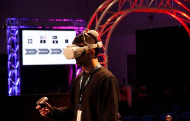 A man wearing a VR headset and holding a control