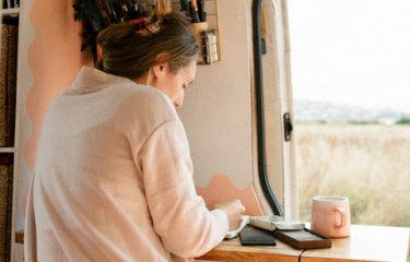 A woman drawing in her van