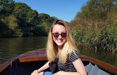 Student Lucy sat on a small boat on a lake