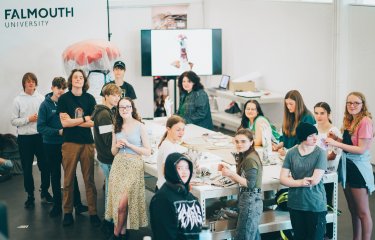 A group of young people making artworks on a large table