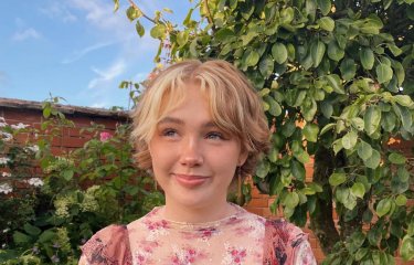 Photograph of Falmouth graduate Niamh Shergold outside with blue sky