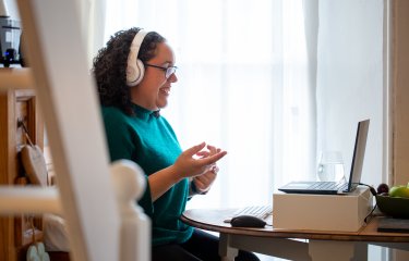 Woman sat at laptop laughing