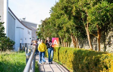 A group of people walking outside at a Falmouth University Open Day