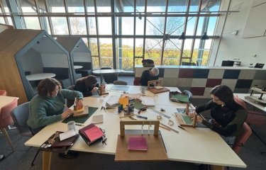 Group of people bookbinding at a table