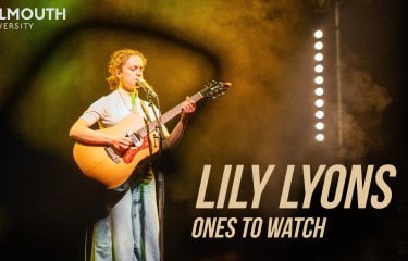 A woman playing a guitar on a stage 