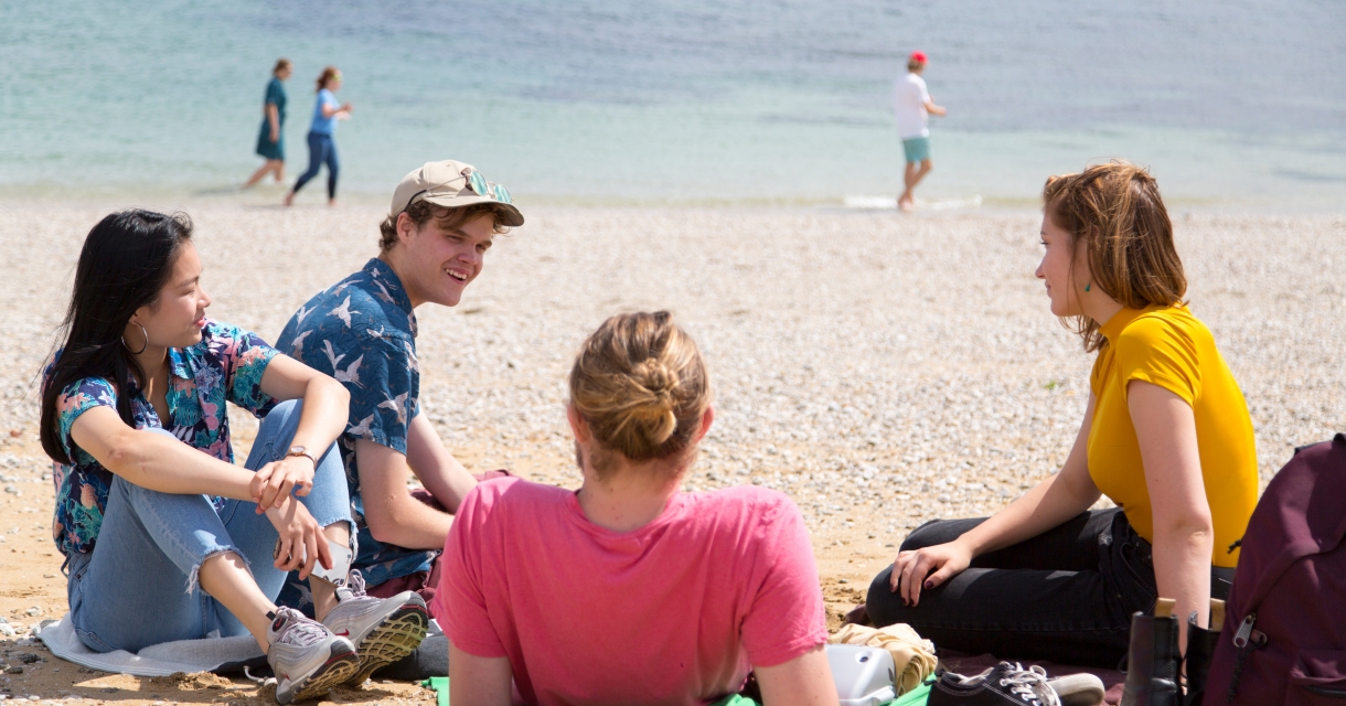 Students relaxing on beach.