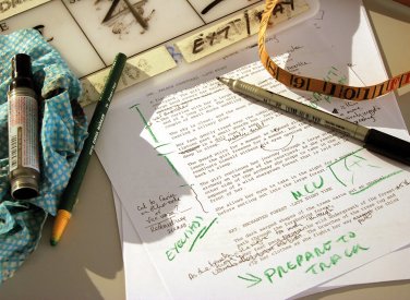 A printed piece of paper with green ink annotations and pens