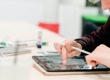A student drawing on an iPad with a pen