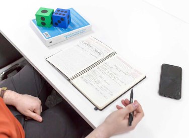 A student doing data calculations in a notebook