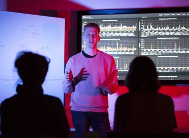 A student giving a presentation on coding