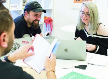 Creative advertising students discussing work