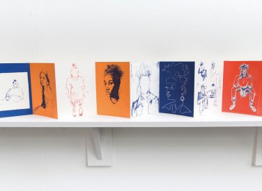 A fold out book of drawings on a shelf