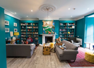Students sat on sofa in a room full of books