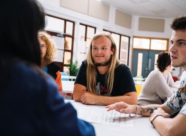 Students sat around a desk chatting
