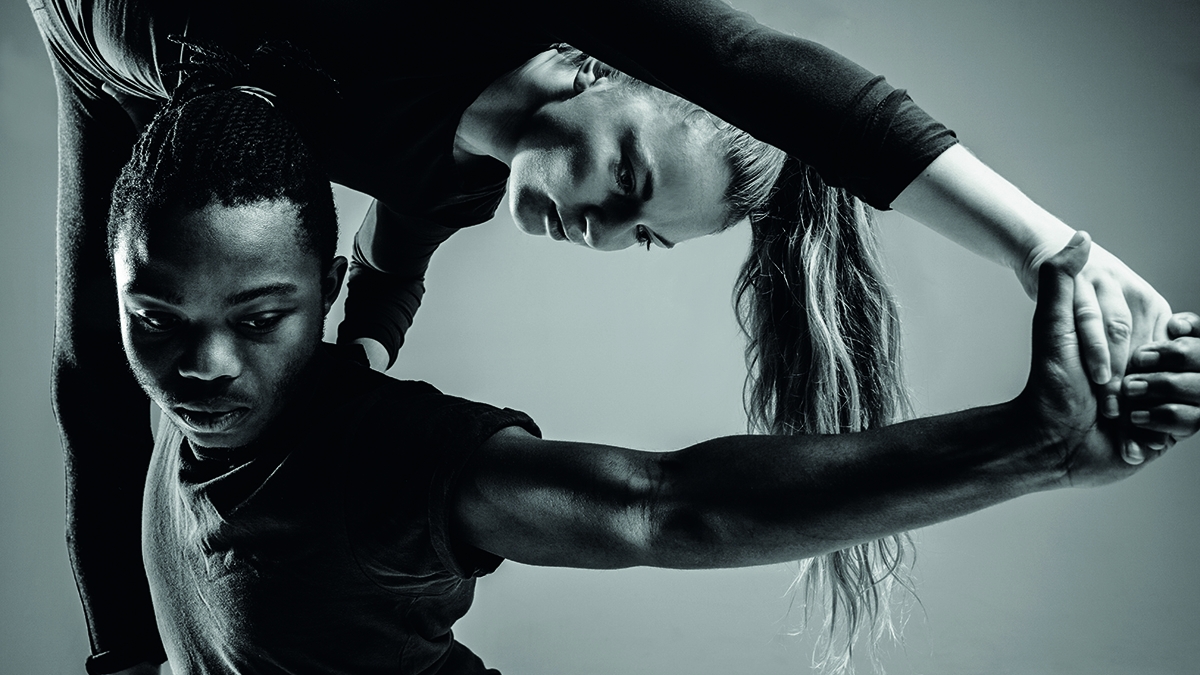 Dancer lifting partner and creating triangle shape with arms