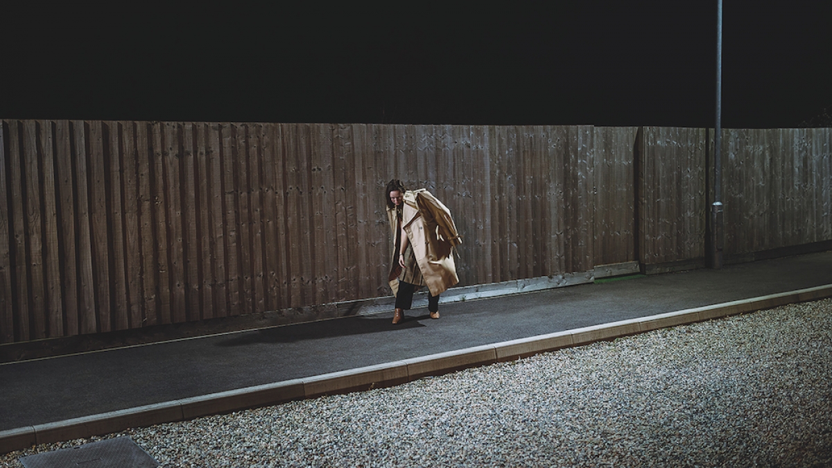 Fashion Photography Work by Nicholas Drabble Shot of model wearing a coat over her shoulders on a pavement at night.