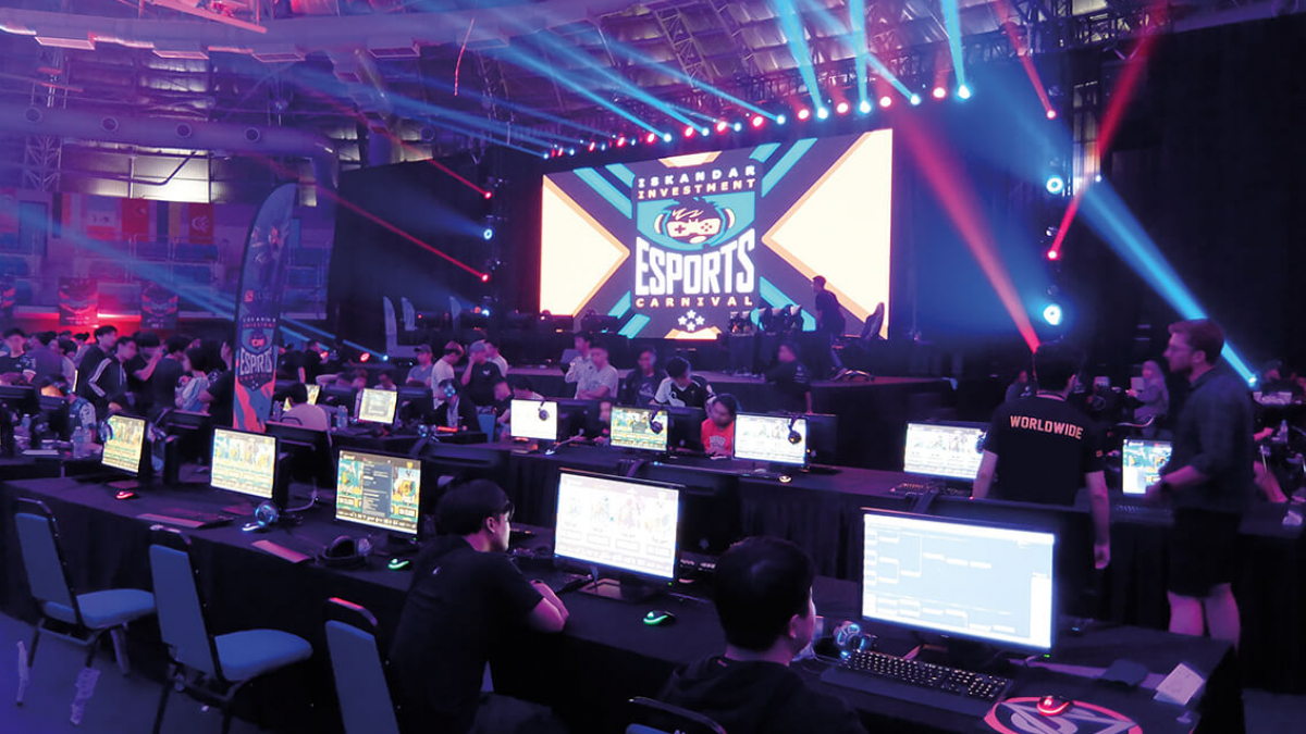 An open plan gaming studio with computers and a large screen