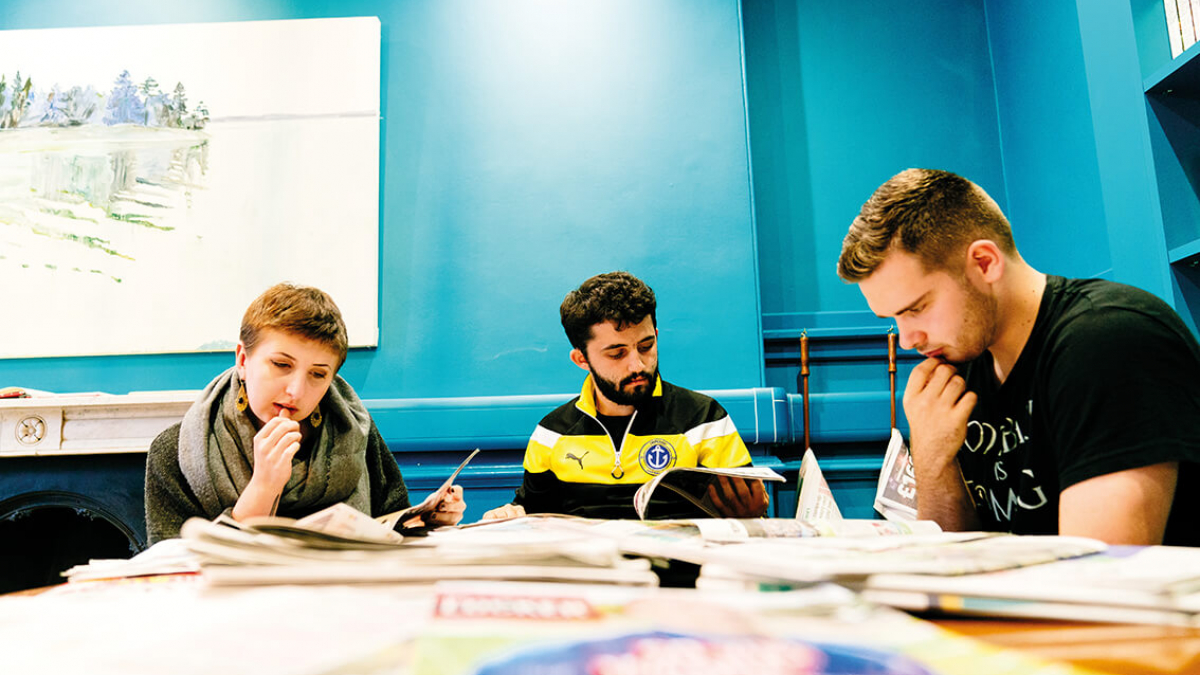 Three Journalism and Creative Writing students studying at a table