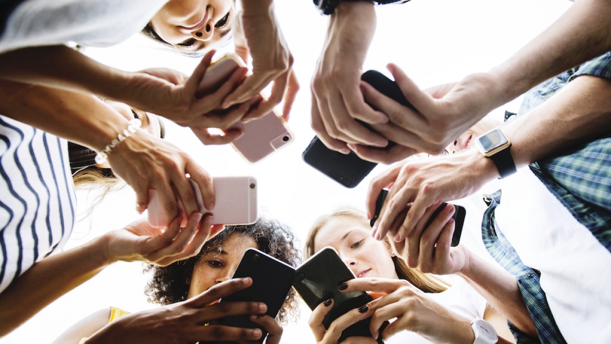 Young people using their phones in a circle