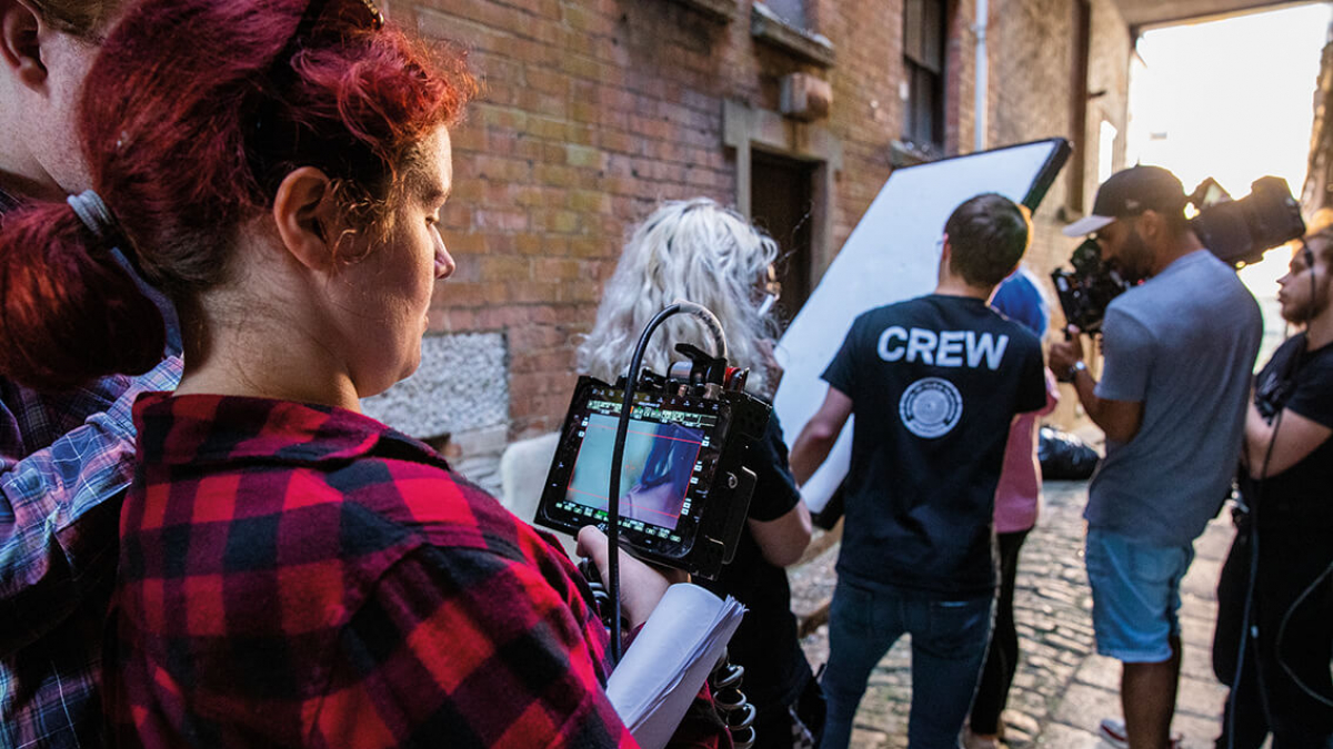 A group of Television students on a television production set with a camera