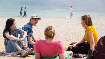 Falmouth University students relaxing on the beach