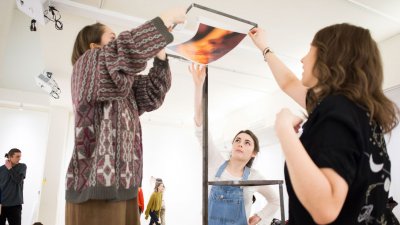 Falmouth students attaching a photograph to a rectangle frame.