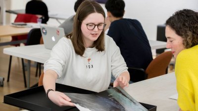 Falmouth University student showing photography portfolio to lecturer.