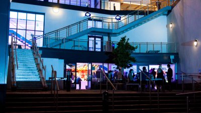 AMATA building with external staircases lit up in blue and purple.