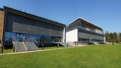 Exterior of the AMATA building on Penryn Campus with grass and blue sky