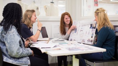 Falmouth University students discussing work on boards in a studio.