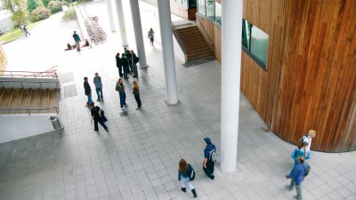 View down onto Penryn campus foyer and people walking and chatting.