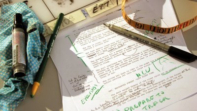 A printed piece of paper with green ink annotations and pens