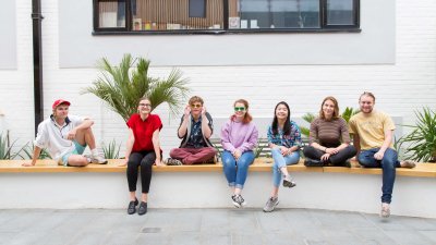 Student smiling and sitting on wall in Fox cafe.