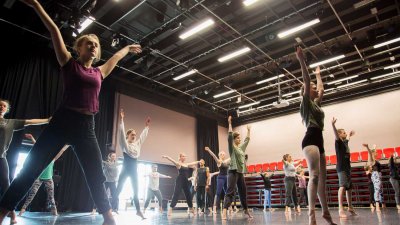Falmouth University dance students raising their arms in a dance studio