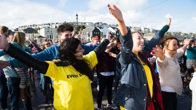 Falmouth Creative Events Management students outside with arms in the air gaining experience on Channel 4 documentary