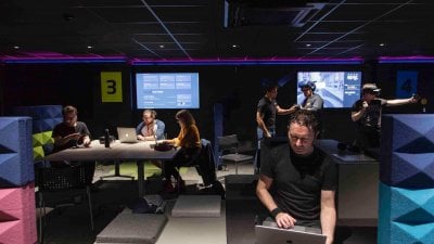 students sitting in a games studio with screens at Falmouth University