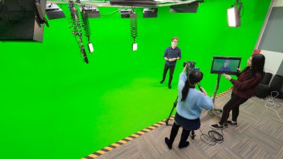 Television students presenting and filming with a green screen in studio at Falmouth University