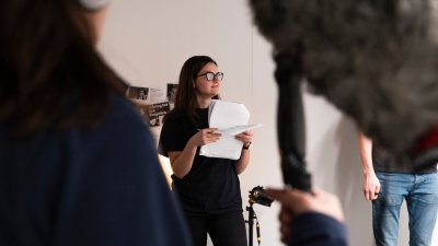 Film student standing holding pieces of paper