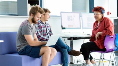 Three Falmouth University students seated talking