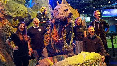 Falmouth University Games Academy students standing in front of a large dinosaur model