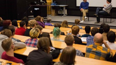 guest lecturer John Maclean on a stage with Film students sitting in an auditorium