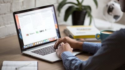 Man studying from home on laptop with house plant